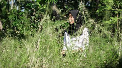 Woman sitting on grass in field