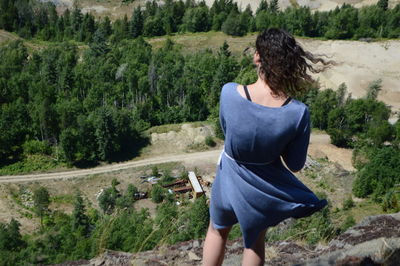 Rear view of young woman standing in forest