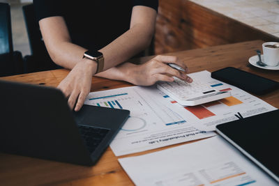 Midsection of businessman working on table