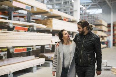 Couple looking at each other while walking in hardware store warehouse