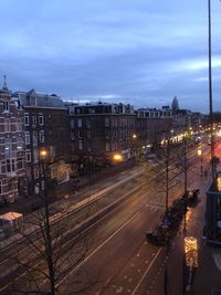 High angle view of illuminated street by buildings against sky