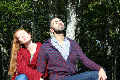 Young couple sitting on tree