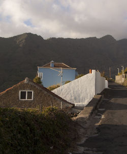 Houses by buildings against sky in city