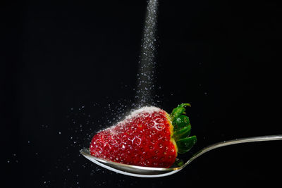 Close-up of strawberry over black background