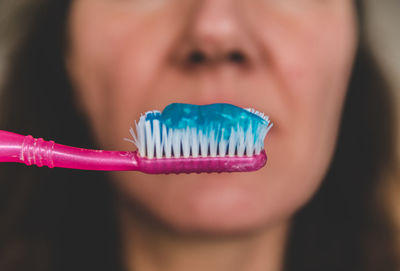 Close-up midsection of woman with toothpaste and brush