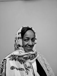 Portrait of smiling woman against gray background