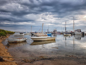 Boats moored on shore against sky