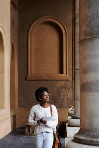 Young woman looking down while sitting in building