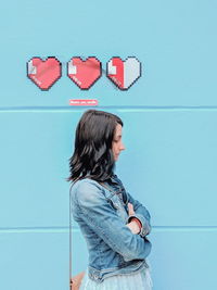 Side view of woman standing against wall