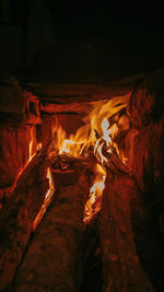 Close-up of fire on log at night