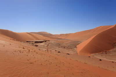 Scenic view of desert against clear blue sky