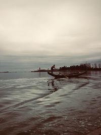 People in boat on sea against sky