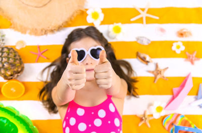 Young woman wearing sunglasses while standing against wall