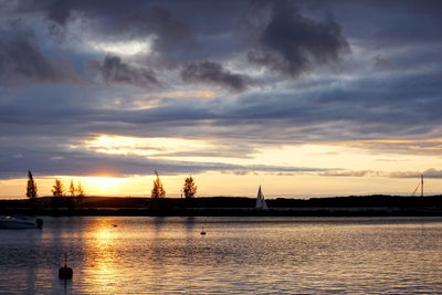 Silhouette of sailboats in sea during sunset