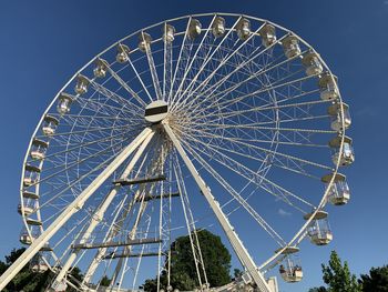 Low angle view of ferris wheel against blue sky