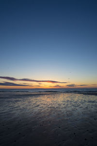 Scenic view of beach against sky during sunset