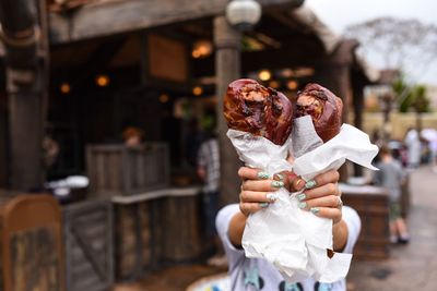 Close-up of woman holding roasted turkey leg