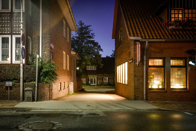 Street amidst illuminated buildings at night