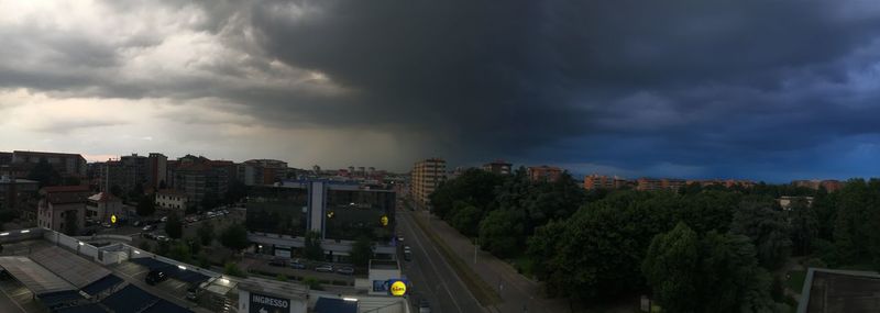 High angle view of buildings in city against storm clouds