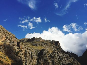 Low angle view of mountain against blue sky