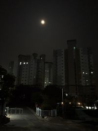 Low angle view of illuminated buildings against sky at night