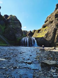 Scenic view of waterfall against sky
