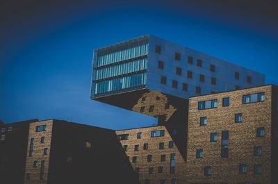 Low angle view of modern building against blue sky