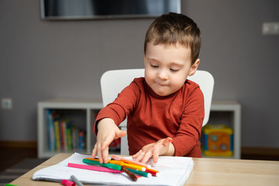 Portrait of boy looking away while sitting at home