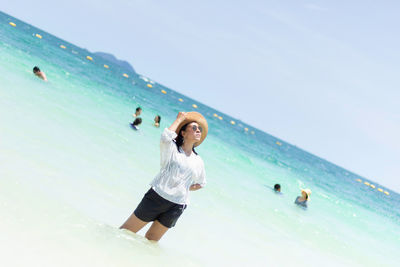 Young woman in sea against clear sky