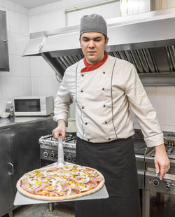 Man preparing pizza in restaurant