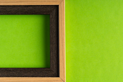 Close-up of empty chair against green wall