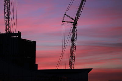 Low angle view of silhouette electricity pylon against romantic sky