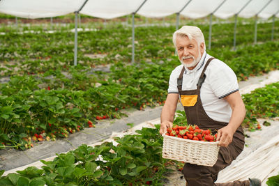 Full length of a smiling young man standing in basket