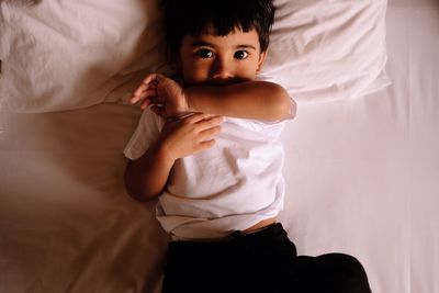 Portrait of boy lying on bed at home