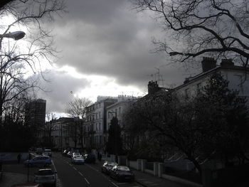 Cars on street in city against sky