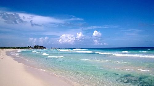 Scenic view of beach against blue sky