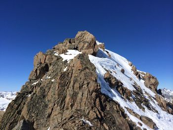 Low angle view of rock formation against clear blue sky