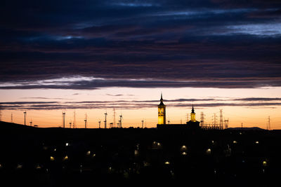 Low angle view of electricity pylon against sky during sunset