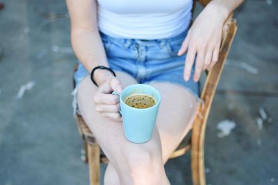 Midsection of woman with coffee cup