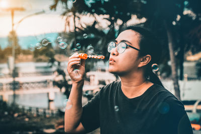 Woman blowing bubbles in city