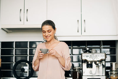 Portrait of a smiling young woman using smart phone