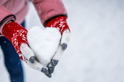 Close-up of hand holding heart shape in winter