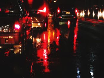 Illuminated city street during rainy season at night