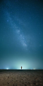 Rear view of man standing on mountain against sky at night