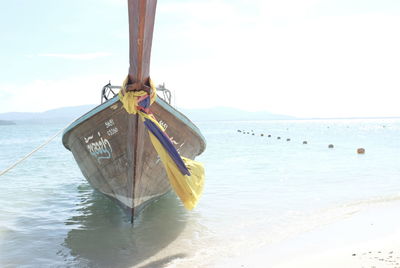 Close-up of boat hanging on beach against sky