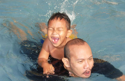 Portrait of shirtless boy swimming in pool