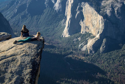 High angle view of female friends relaxing on cliff at yosemite national park
