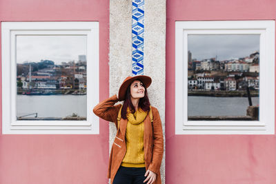 Portrait of woman standing against building