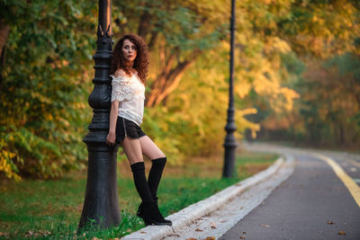 Portrait of woman standing by plants during autumn