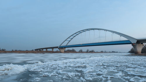 Bridge over snow against sky